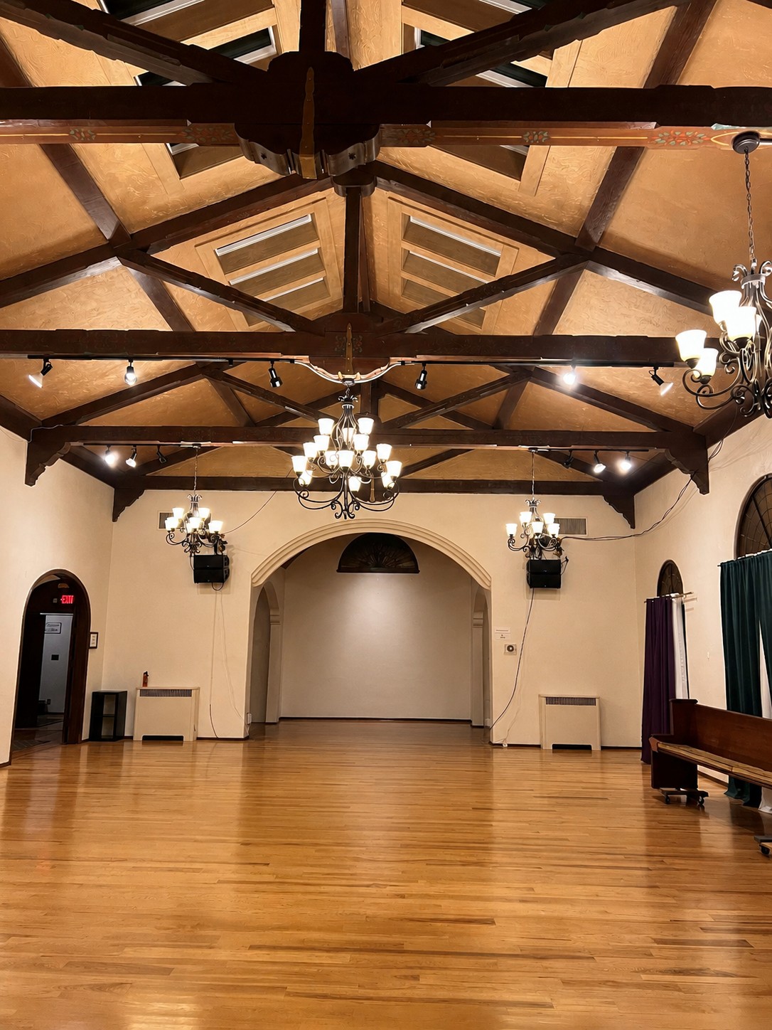 The Oak Grove ballroom with vaulted ceiling, chandeliers, and a polished wooden dance floor.