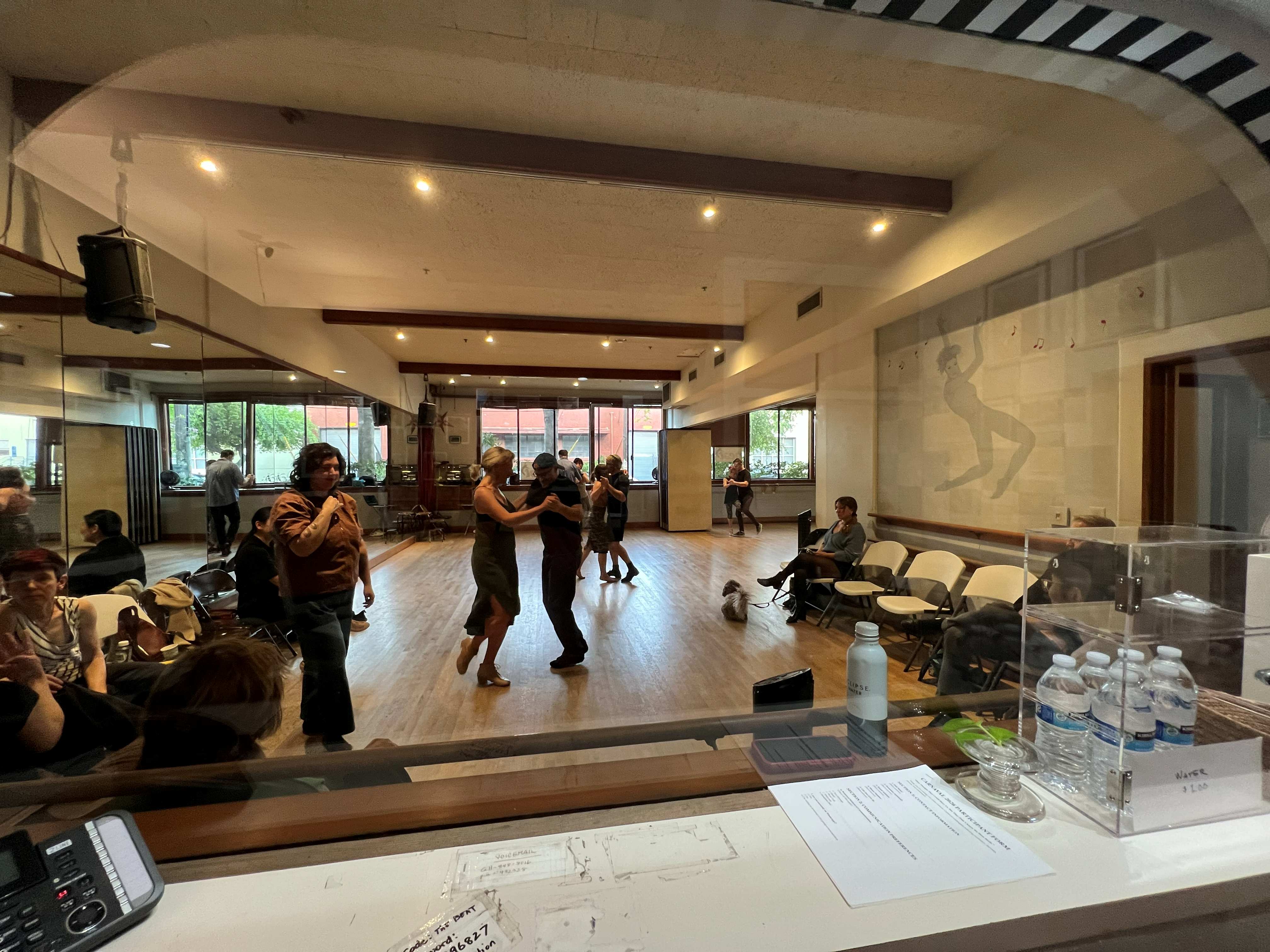 Dancers practicing tango on the wooden dance floor at The Beat in Berkeley.