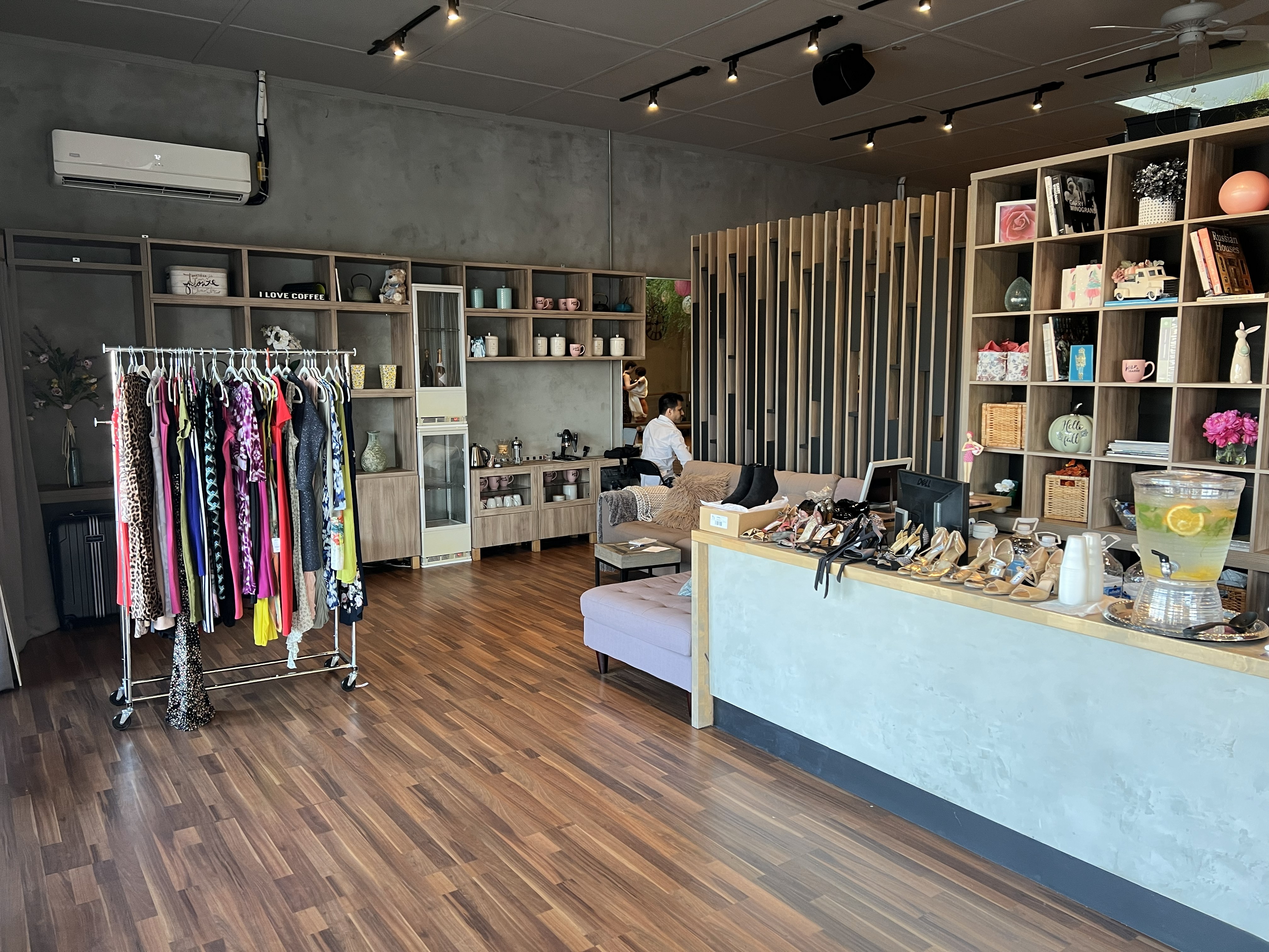 Interior of Wild & the Barre studio with tango dresses on a clothing rack and tango shoes displayed near the seating area.