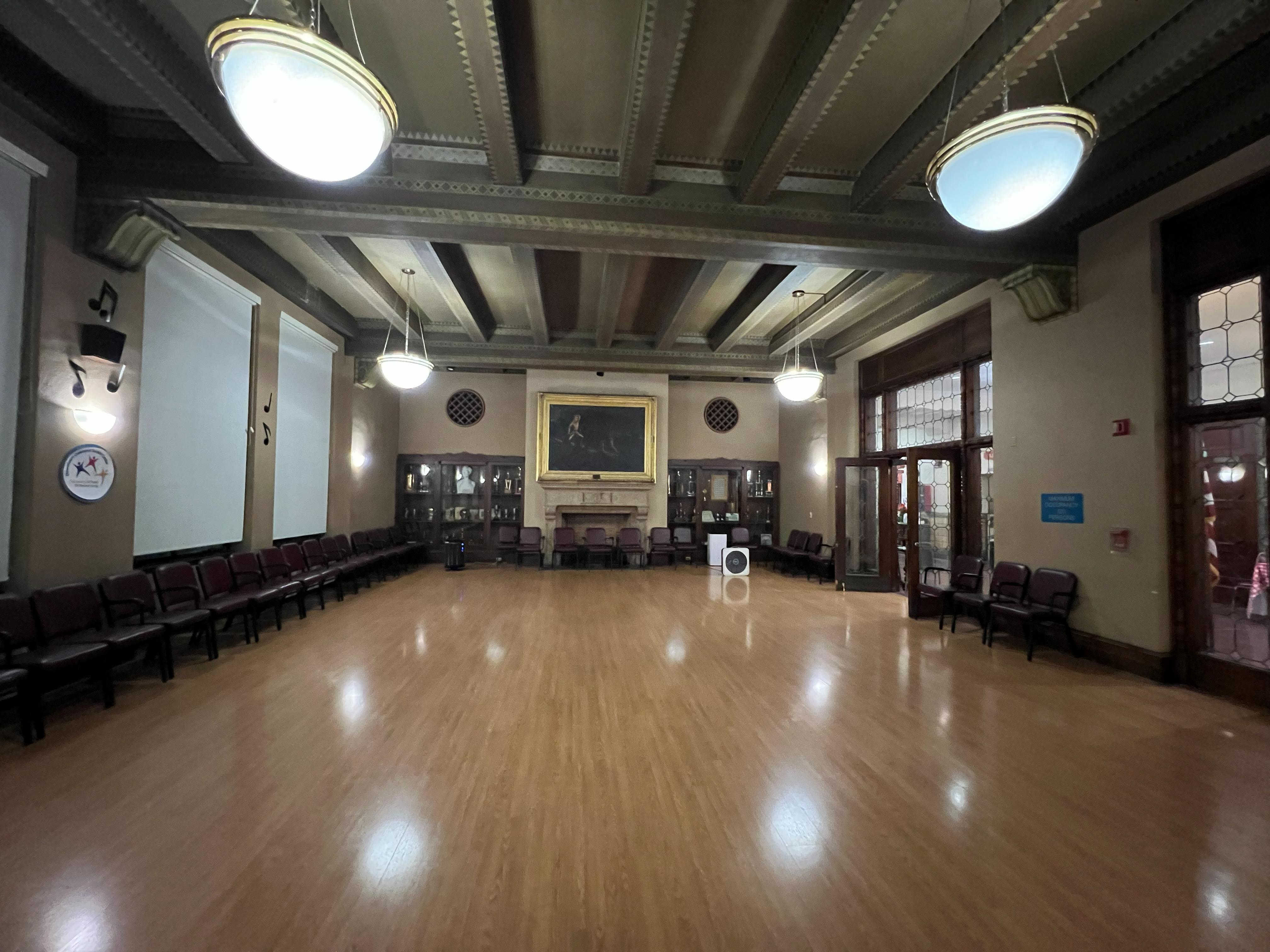 Smaller room inside the Veterans Memorial Building with chairs along the walls and polished flooring.